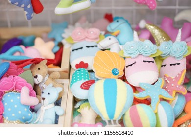 Felt Animals. A Pile Of Stuffed Animals, Hot Air Balloons, Starfish And Other Objects Made From Felt With Selective Focus On The Pink Unicorn.