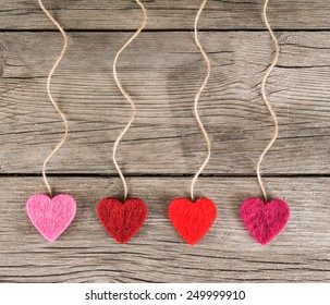  felt fabric love valentine's hearts hanging on rustic driftwood texture background with twine  - Powered by Shutterstock