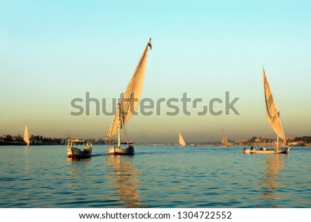 Similar – Silhouette einer ägyptischen Stadt mit Segelboot im Vordergrund und pastellrosa-lila farbenem Himmel, Sonnenuntergangsstimmung