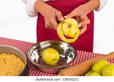 Femael hands peeling apples to prepare a traditional pie