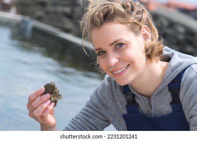 femael shell farmer holding fresh oysters