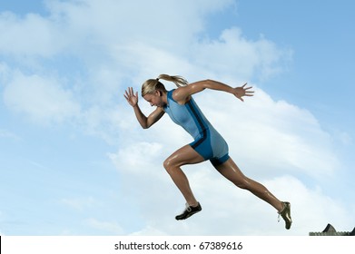 Femaile sprinter leaps from starting block. - Shutterstock ID 67389616