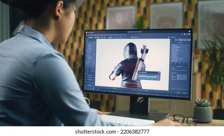Female 3D designer creating and drawing character for video game using computer while sitting at the table at home office and doing distant work. 3D modeling