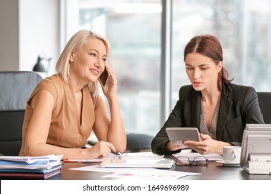 Female accountant and her colleague working in office