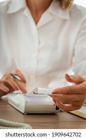 Female Accountant Using Adding Machine While Working On Company Paperwork.