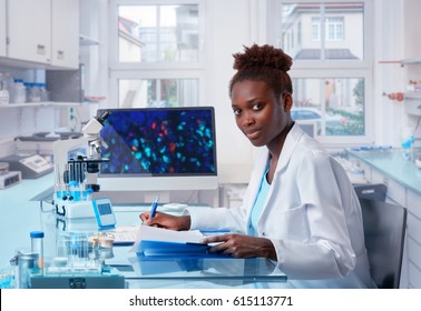 Female African Scientist, Medical Worker, Tech Or Graduate Student Works In Modern Biological Laboratory. This Image Is Toned.