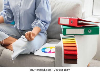 Female African-American graphic designer meditating on sofa in office, closeup - Powered by Shutterstock