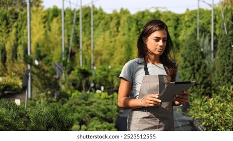 Female agricultural engineer using a digital tablet and planning planting at the garden center - Powered by Shutterstock