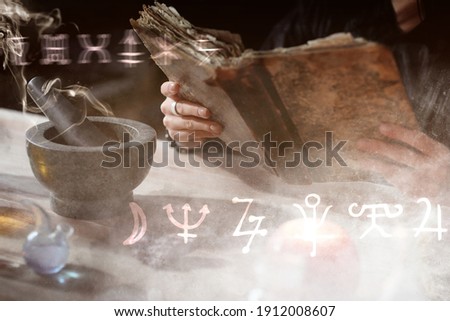 Female alchemist with old book making elixir in laboratory, closeup