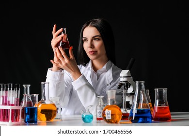 Female Alchemist With Potions At Table