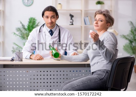 Female alcoholic visiting young male doctor