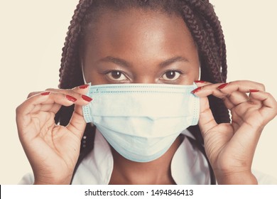 Female American African Doctor, Nurse Woman Wearing Medical Coat With Stethoscope And Mask. Happy Excited For Success Medical Worker Posing On Light Background