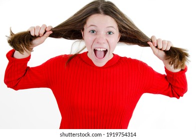 Female Angry Concept - Young Teenage Girl Showing Childish Anger And Tantrum. Isolated On White Background. A Very Frustrated And Angry And Upset Girl Is Screaming Out Loud And Pulling Her Hair.