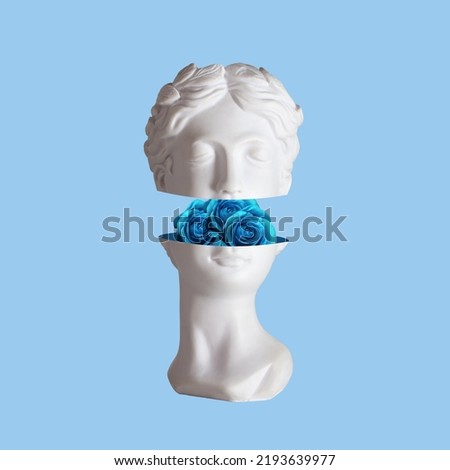 Female antique statue's head with blue flowers roses in the cut isolated on a blue color background. The beauty inside. Trendy collage in magazine surreal style. 3d contemporary art. Modern design