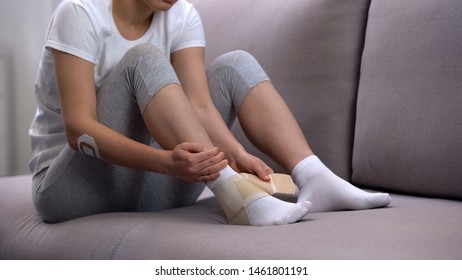 Female Applying Two-strap Ankle Wrap, Suffering Foot Edema After Sport Trauma