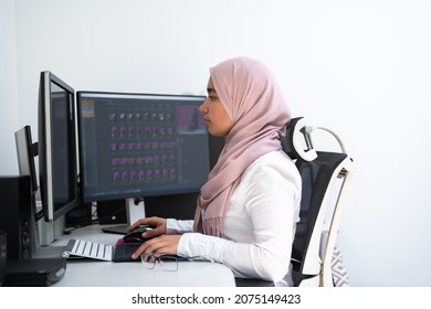 Female Arabic creative professional working at home office on desktop computer with dual screen monitor top view. Selectve focus  - Powered by Shutterstock