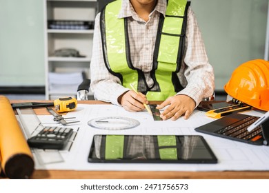 Female architect engineer is drafting blueprints using CAD software, focusing on sustainable infrastructure, renewable energy solutions, and adhering to building codes - Powered by Shutterstock