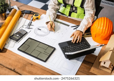 Female architect engineer is drafting blueprints using CAD software, focusing on sustainable infrastructure, renewable energy solutions, and adhering to building codes - Powered by Shutterstock