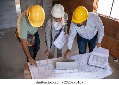 A female architect and a focused construction managers engage in an animated discussion, analyzing blueprints. - Powered by Shutterstock