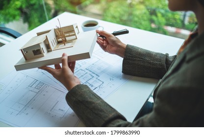 A Female Architect Holding And Working On An Architecture House Model With Shop Drawing Paper In The Office