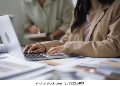 Female architect type data and explain interior building design plan to colleague while taking note. - Powered by Shutterstock