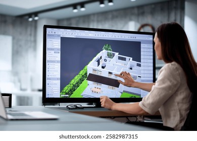 Female architect using 3D software to remodel estate floor plan.