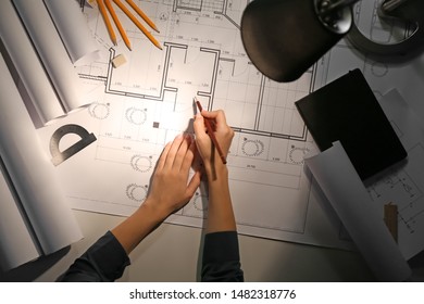 Female Architect Working Late In Evening, Top View