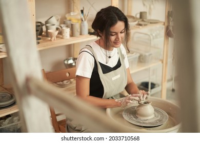 Female artisan making crockery in pottery workshop - Powered by Shutterstock