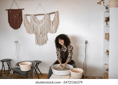 Female artisan sculpting clay on potter's wheel in a cozy, decorated studio. Woman working on ceramic bowl, showcasing creativity and craftsmanship. - Powered by Shutterstock