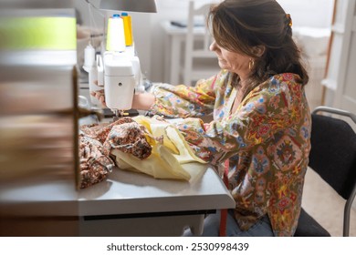 Female Artisan Sewing Colorful Fabric On A Machine, Crafting Handmade Clothing In A Home Studio Setting, Showcasing Creativity And Craftsmanship In Textile Work.Handmade Artisan Craft - Powered by Shutterstock