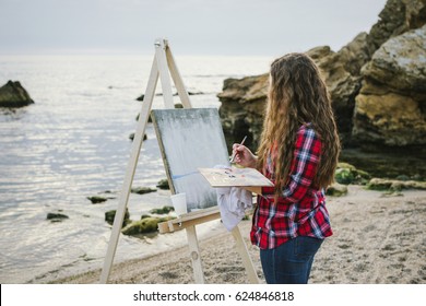 Female artist painting a sea landscape  - Powered by Shutterstock - Get 15% off with code: PIKWIZARD15