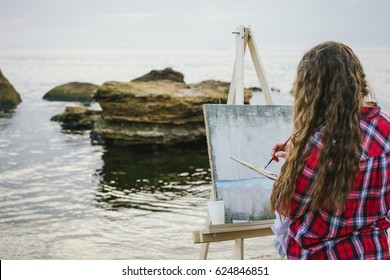 Female artist painting a sea landscape  - Powered by Shutterstock