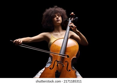 Female artist playing a cello isolated on black background