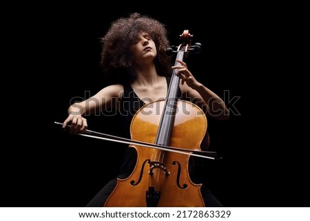 Female artist playing a contrabass isolated on black background