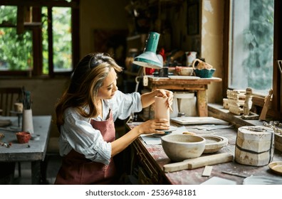 Female artist sculpts crafts with ceramic clay at her creative workshop. Mastering the art of pottery craft ceramics - Powered by Shutterstock