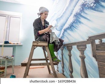 Female Artist Working On A Mural On A Marine Theme In The Room.