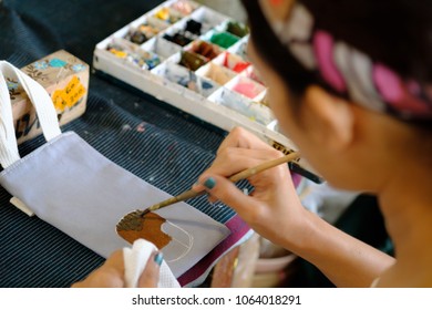 Female Artist Working On Painting In Cloth bag. Background image, selective focus on foreground