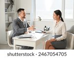 Female Asian applicant with human resources manager at job interview in office