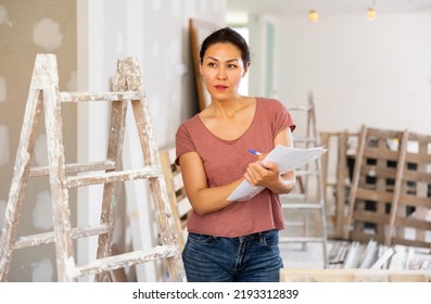 Female Asian Architect Matching Check List During Repair Works In House.