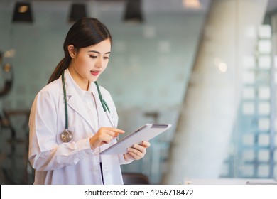 Asiatischer Frauenarzt mit digitaler Tablette 