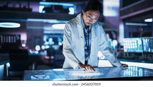 Female Asian Neuroscinetist Using Interactive Touch Screen Table With MRI Scans On Display In Modern Biotechnology Research Center. Doctor Developing Innovative Devices For People With Brain Damage. - Powered by Shutterstock