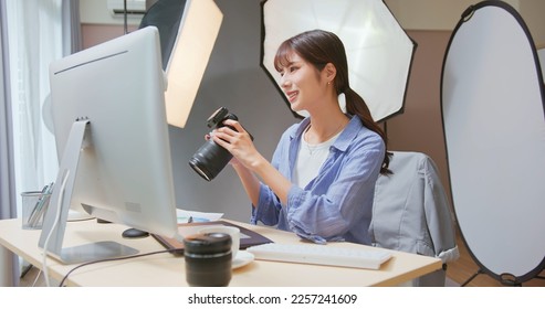 Female Asian photographer reviewing photo with camera - Powered by Shutterstock