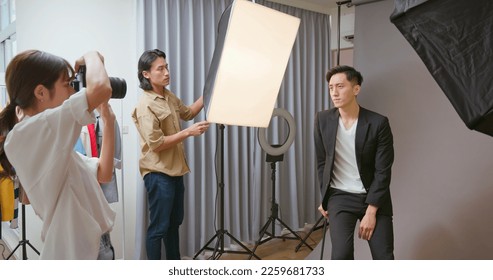 Female Asian photographer shooting photo of male model