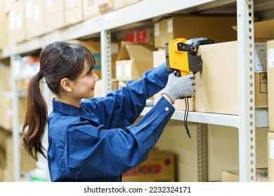 female asian worker managing product in warehouse - Powered by Shutterstock