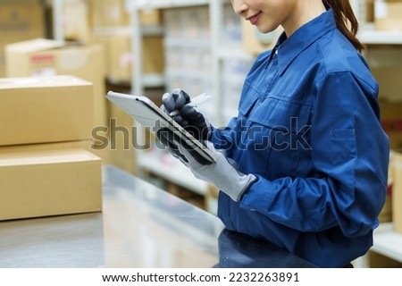 female asian worker managing product in warehouse