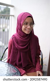 A Female Asian Young Lady Having A Conversation And Not Looking At The Camera