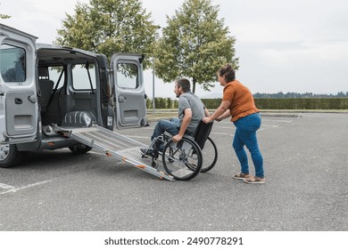 Female assistant helping a male person in wheelchair with transport using accessible vehicle van ramp. Disability and mobility concepts. - Powered by Shutterstock