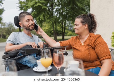 Female assistant helping a man in a wheelchair to use a smartphone. Disability and daily activity concepts. - Powered by Shutterstock