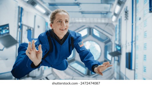 Female Astronaut Floating in International Space Station, Wearing Blue Spacesuit, Smiling. Demonstrates Human Accomplishment in Space Exploration. Scientific Discovery and Technological Achievement. - Powered by Shutterstock