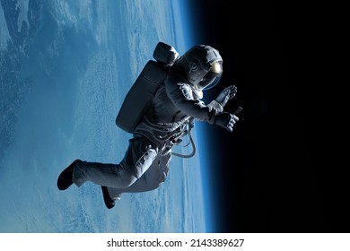 Female astronaut having a video call on her phone while performing spacewalk in deep space, Earth in the background